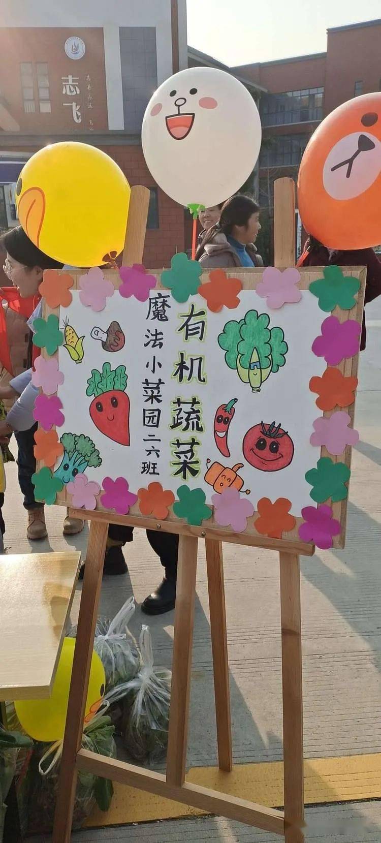 各班早已支起了摊位,摊位旁孩子们精心设计的海报各有特色.