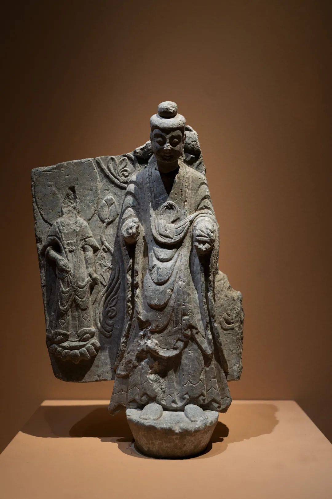 内着僧祗支,胸前束带打结,外穿褒衣博带式袈裟.