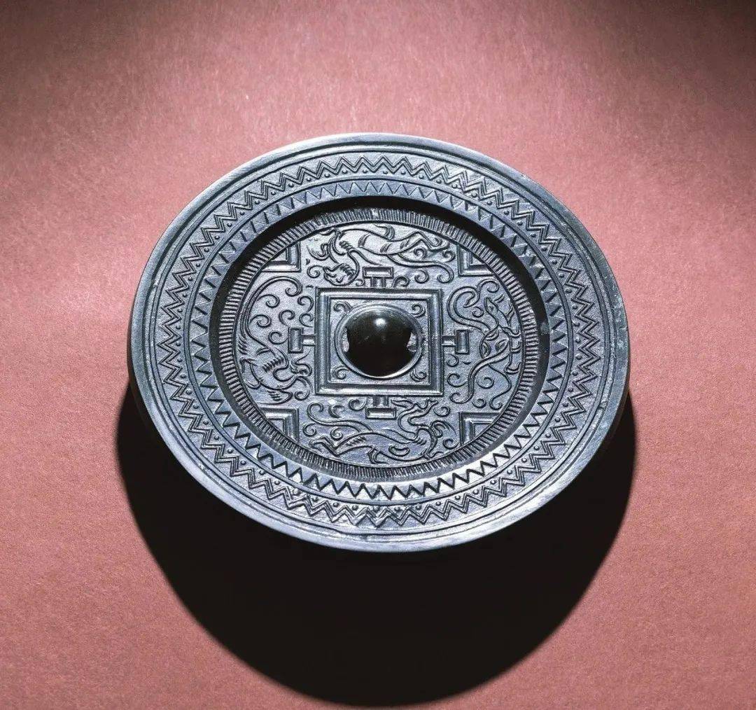 钮座外有两周凸弦纹带,间饰四周栉齿纹,每两周栉齿纹构成一个铭文带.