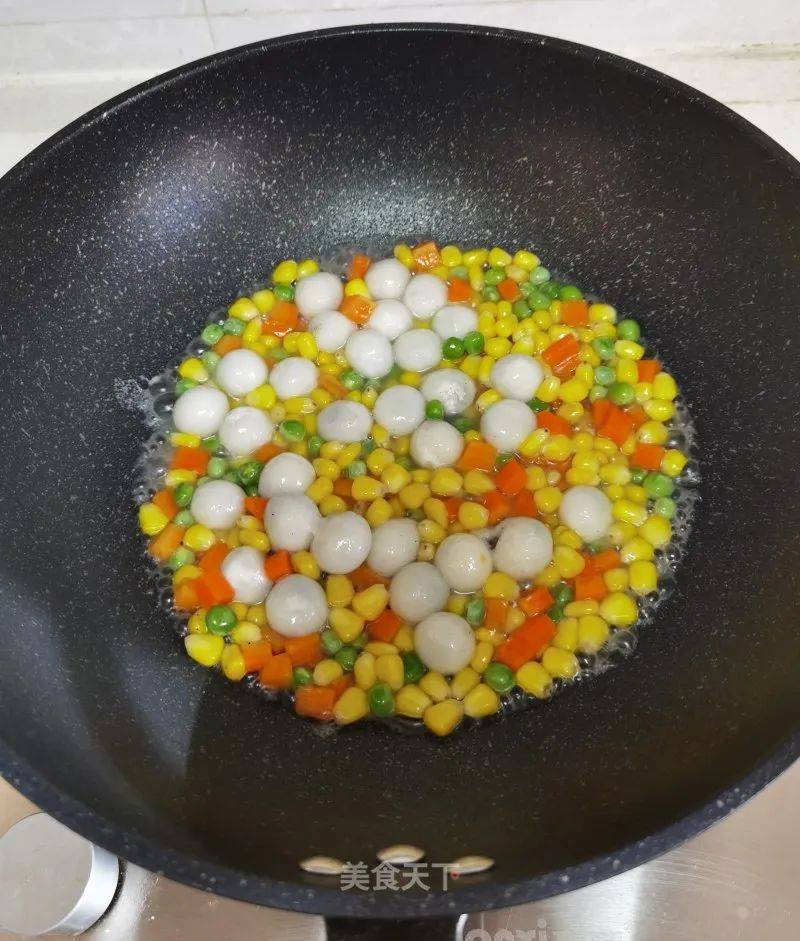 9 有小气泡时将玉米粒,豌豆粒和胡萝卜丁放进去翻炒均匀