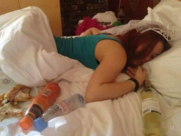 有位女生喝醉后趴在床上睡觉,头上还戴着发饰,身边被酒瓶,饮料瓶和