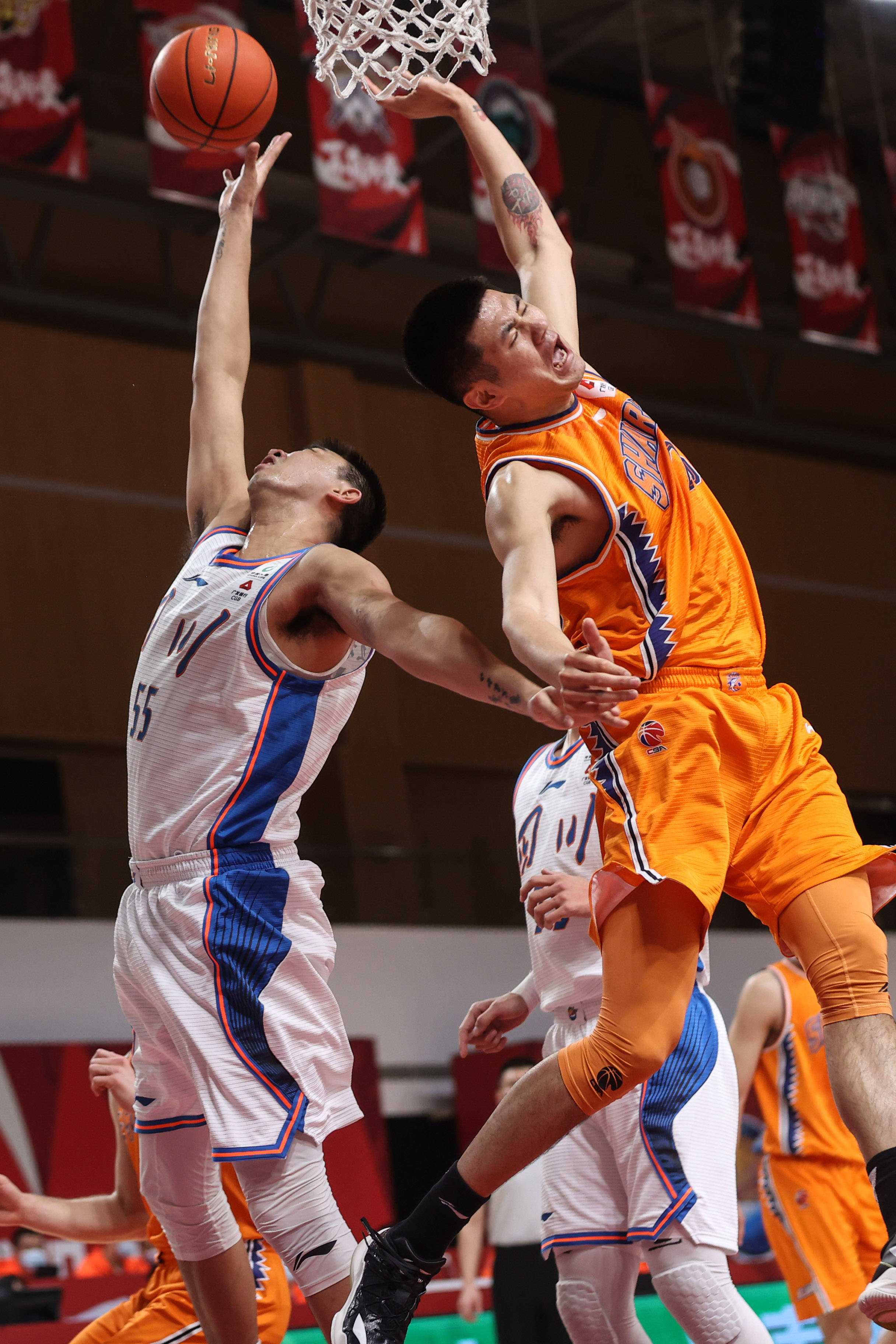 1月25日,四川五粮金樽队球员苏若禹(左)在比赛中拼抢篮板.