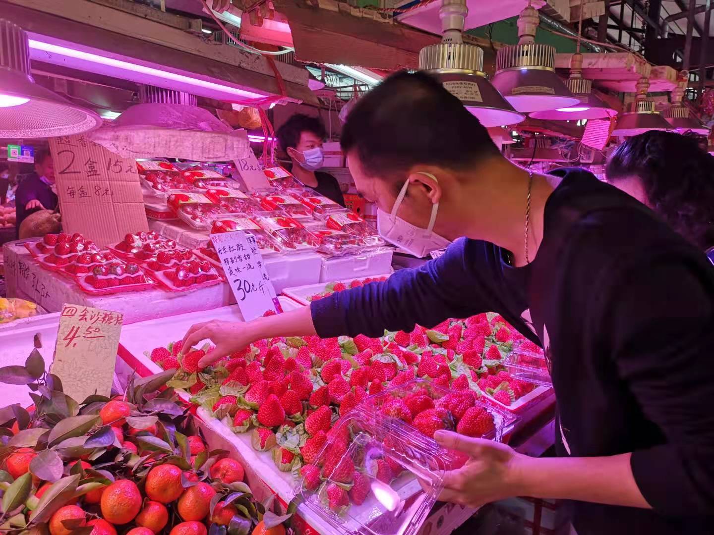 西华农贸综合市场,草莓成了水果摊位的主打产品,丹东红颜草莓30元一斤