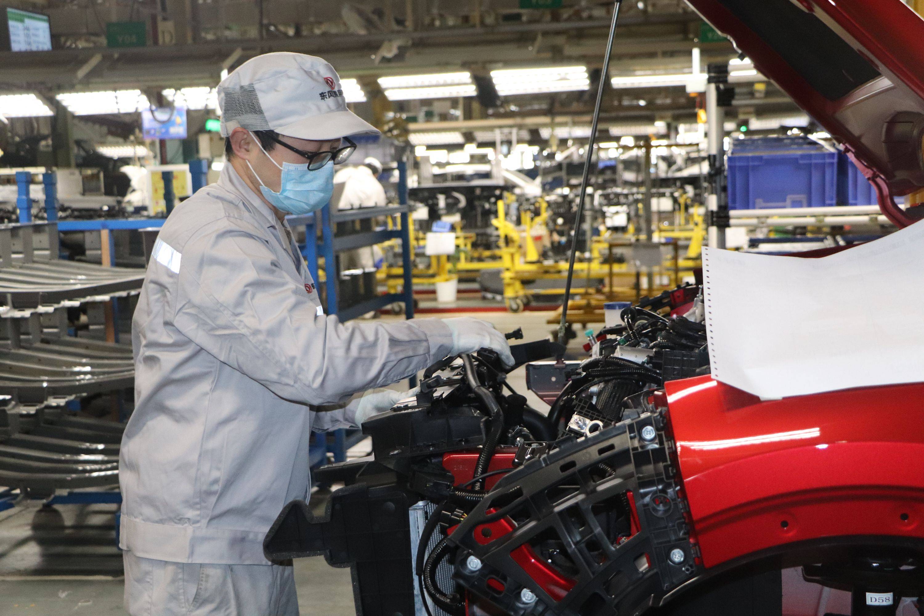 (图为东风乘用车总装车间底盘一班装配工张群正在生产线上作业.