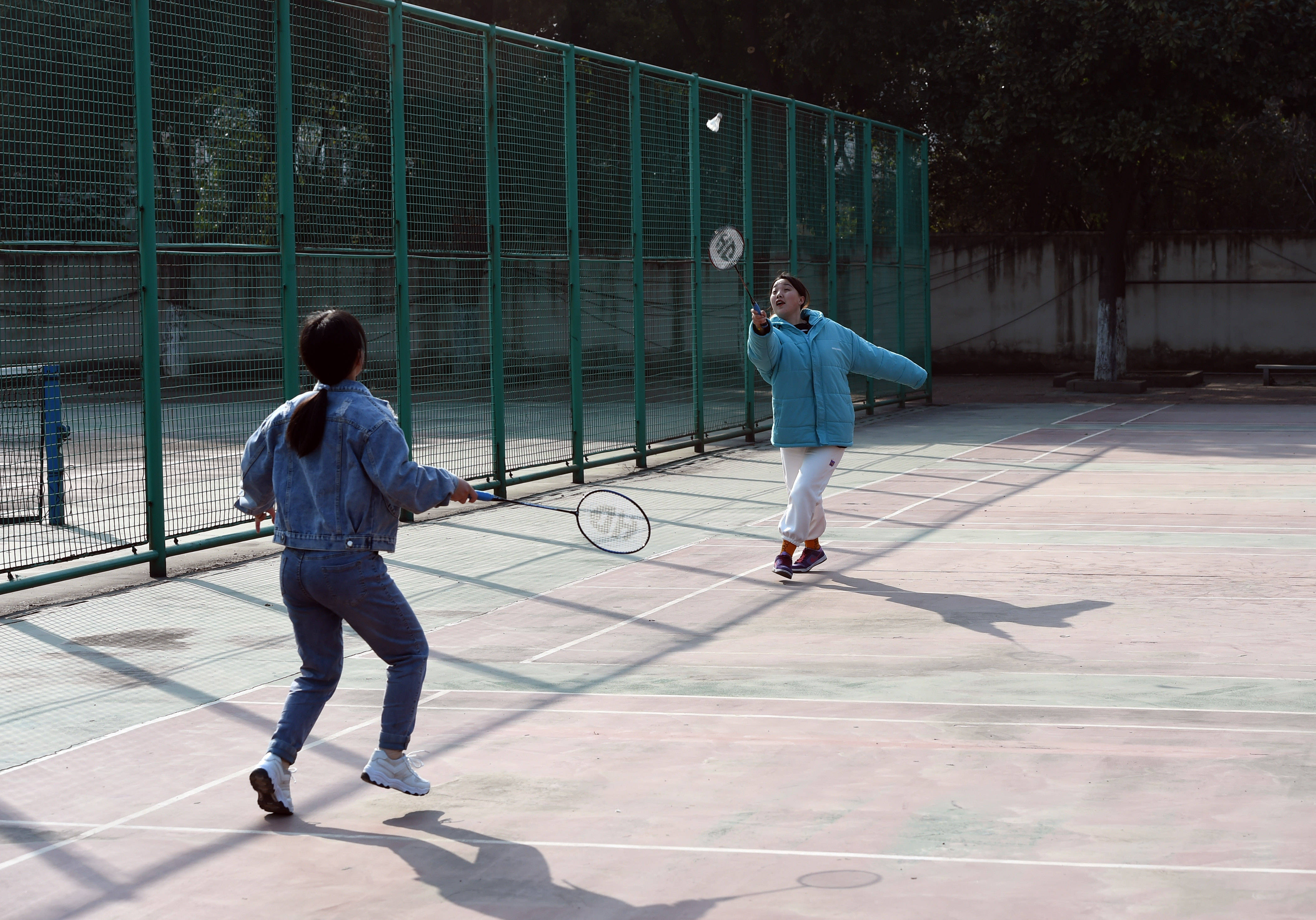 河北石家庄籍学生康怡(右)和梁维玲在打羽毛球