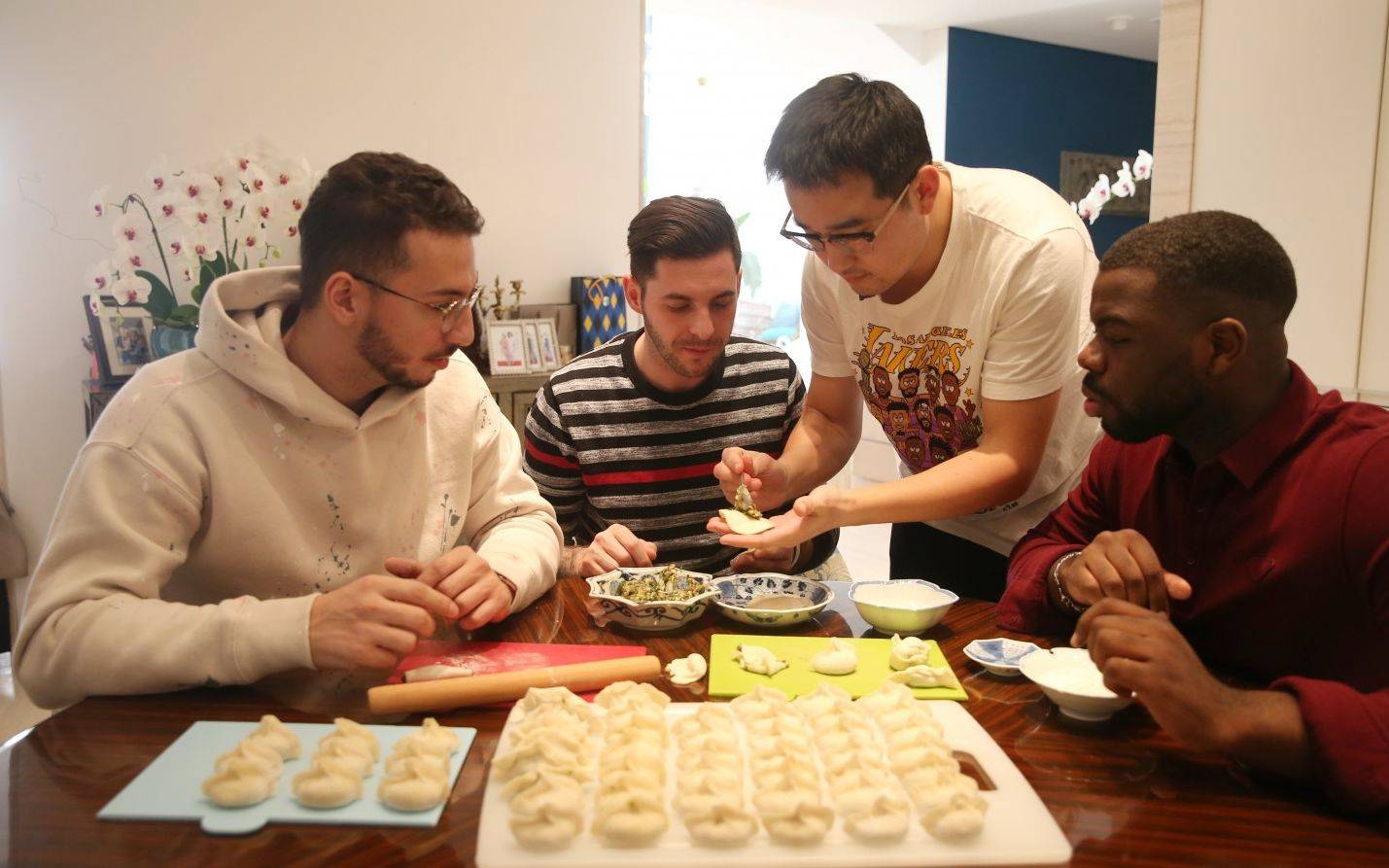 三个人对饺子,火锅,筷子都用得比较溜,他们认同中国人分享红包的文化