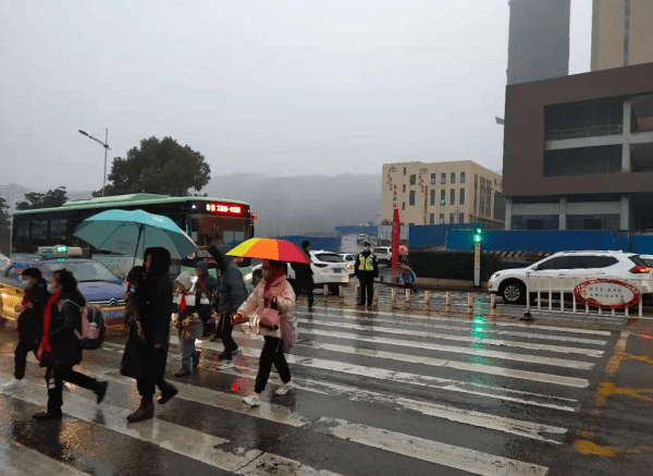 白雲路小學路段,執勤交警護送學生過馬路