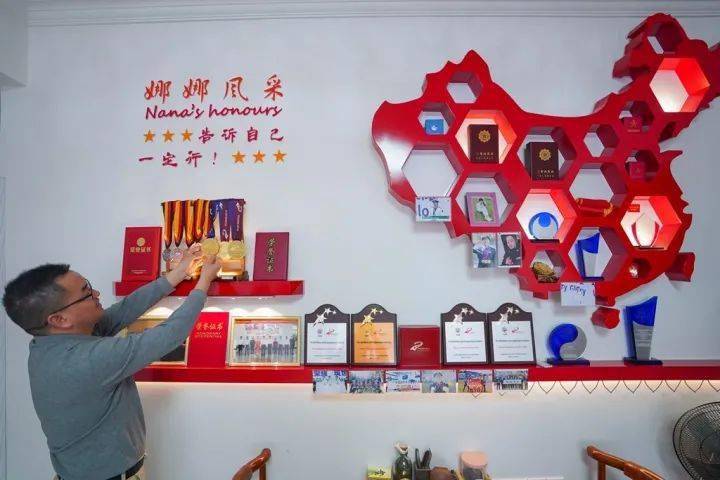 上面悬挂和摆放着张娜两个"三等功"功勋章和许多奖杯,荣誉证书和奖牌