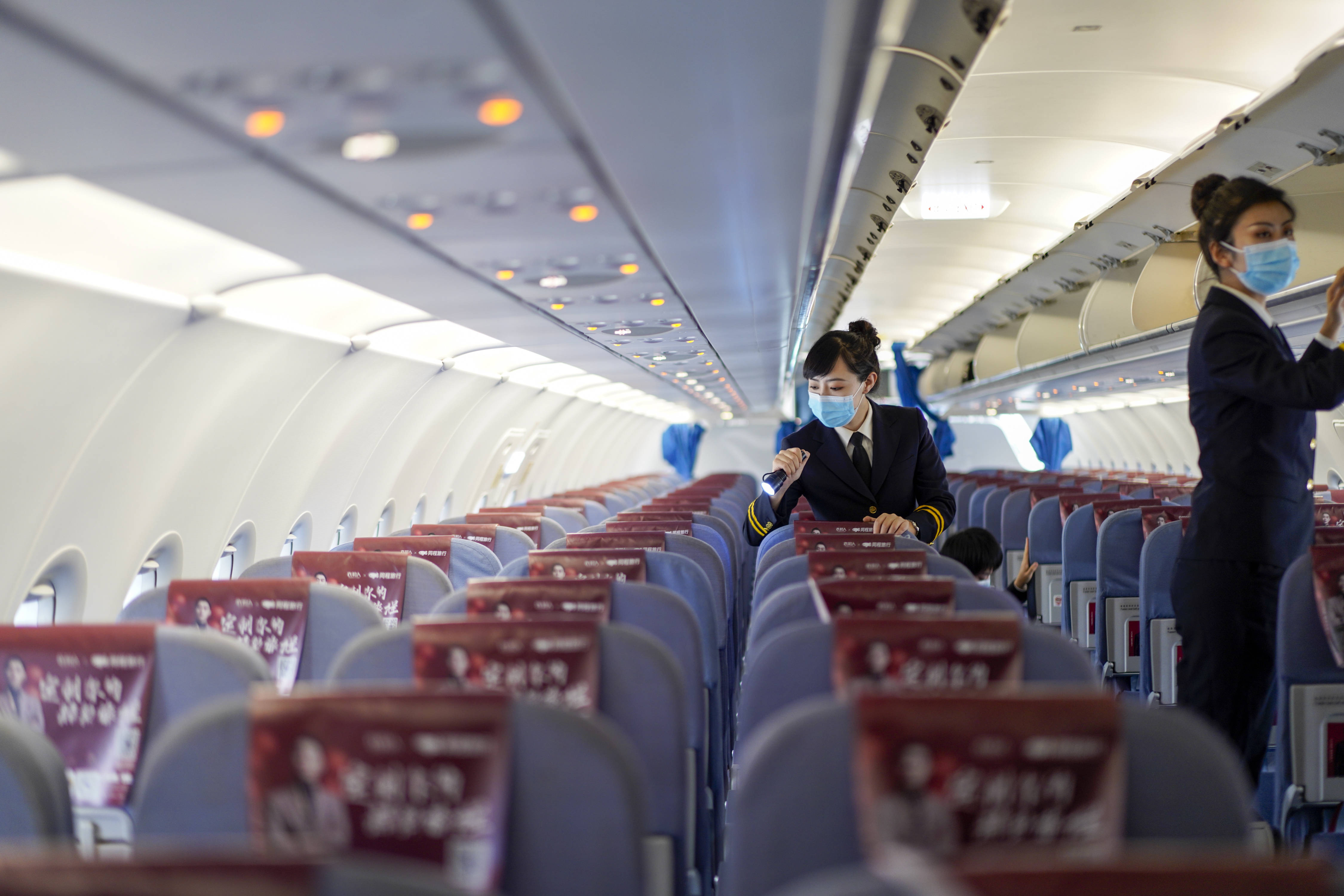 2月25日,华夏航空女子航空安全员在客机机舱内进行安全检查