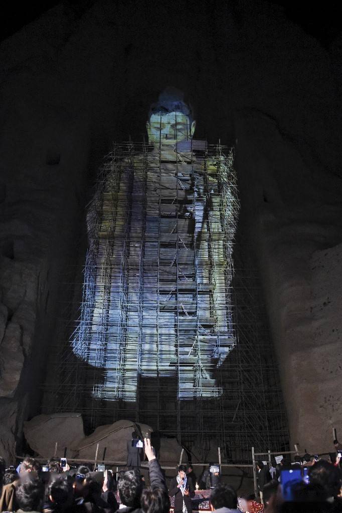 当地人拍照留念以投影重现巴米扬大佛并不是首例.