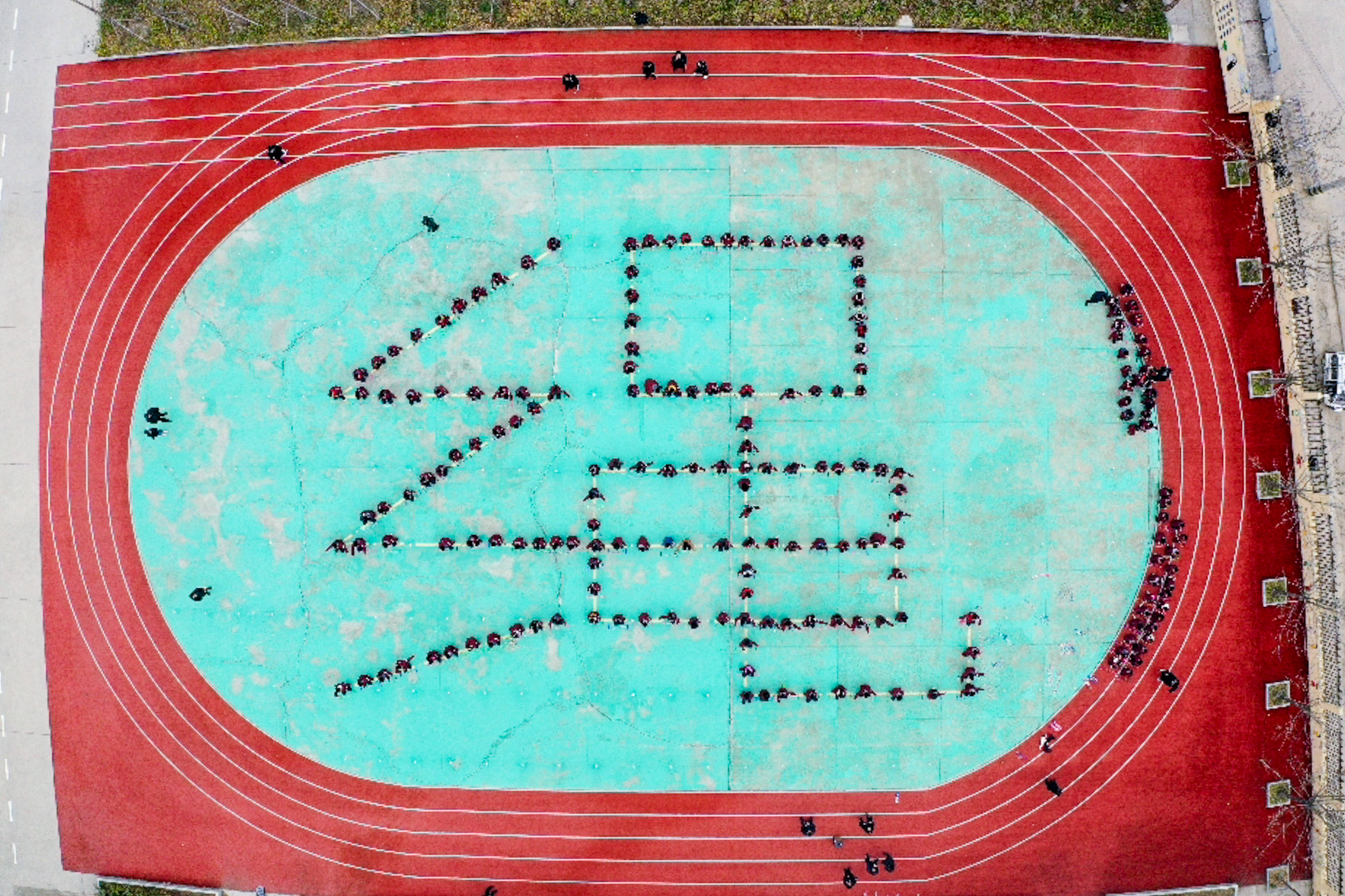 骑路小学的学生们在操场上排列站队成绳字造型(3月9日摄,无人机照片