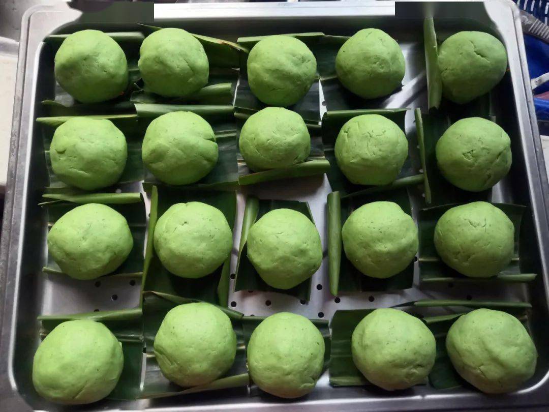 13.逐个包好,搓圆,摆上垫了山姜叶的蒸盘.