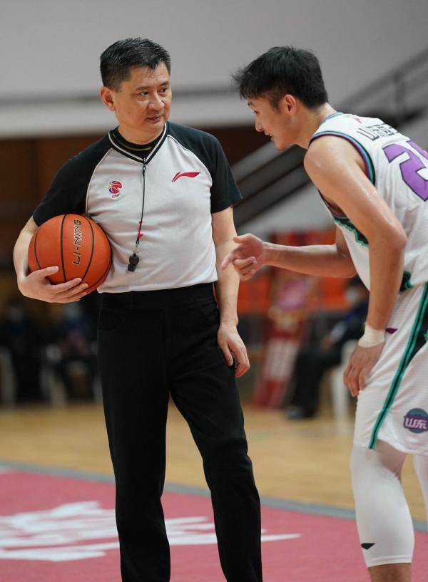 山东西王队球员王汝恒(右)在比赛中与主裁判宋晓竞交流.