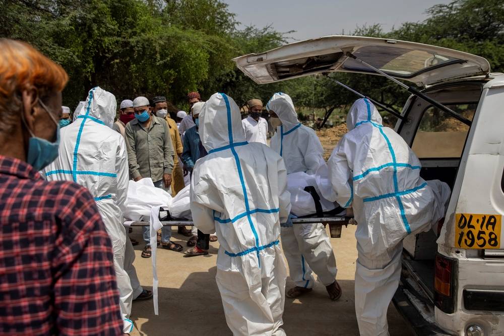 当地时间2021年4月28日,印度新德里,新冠死者尸体被抬到街边等待火化.