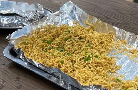 焯过水的公仔面在炭火上翻炒锡纸上各种咸香的烧烤酱料特色锡纸面也是