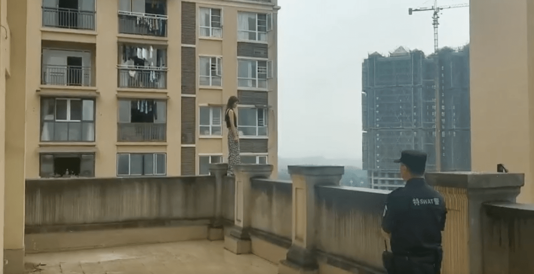 瑟瑟发抖宜宾一女子站在12楼天台围墙上行走要跳楼