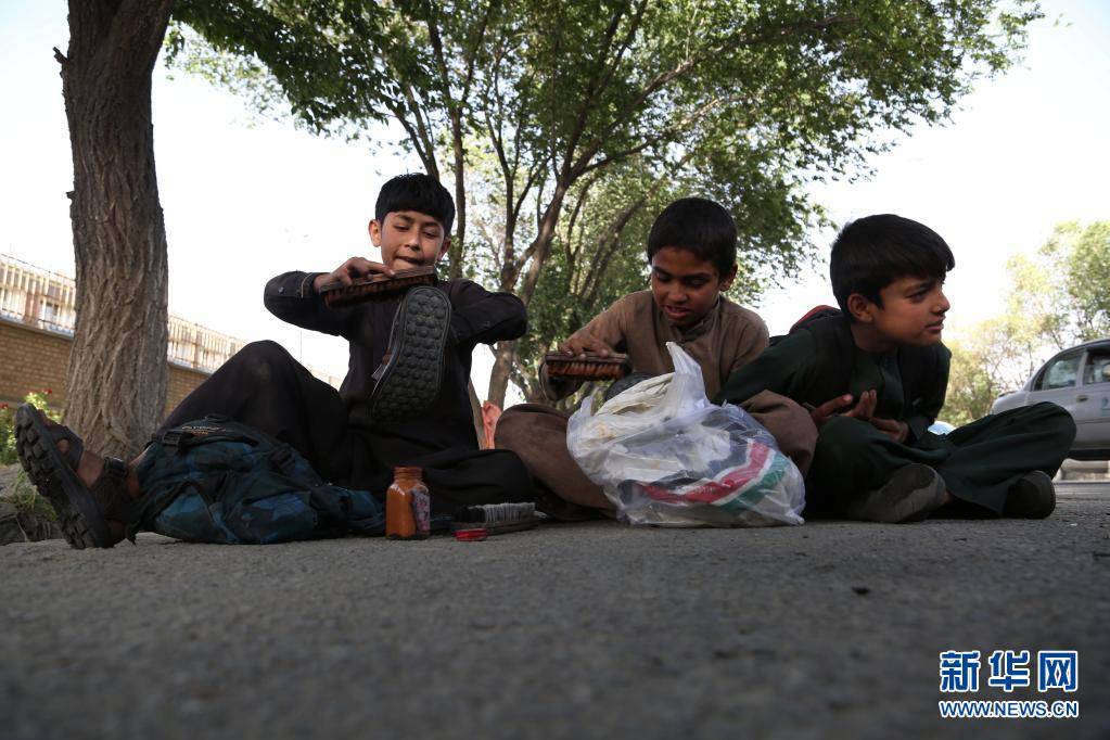 6月11日,几名童工在阿富汗首都喀布尔街头擦鞋