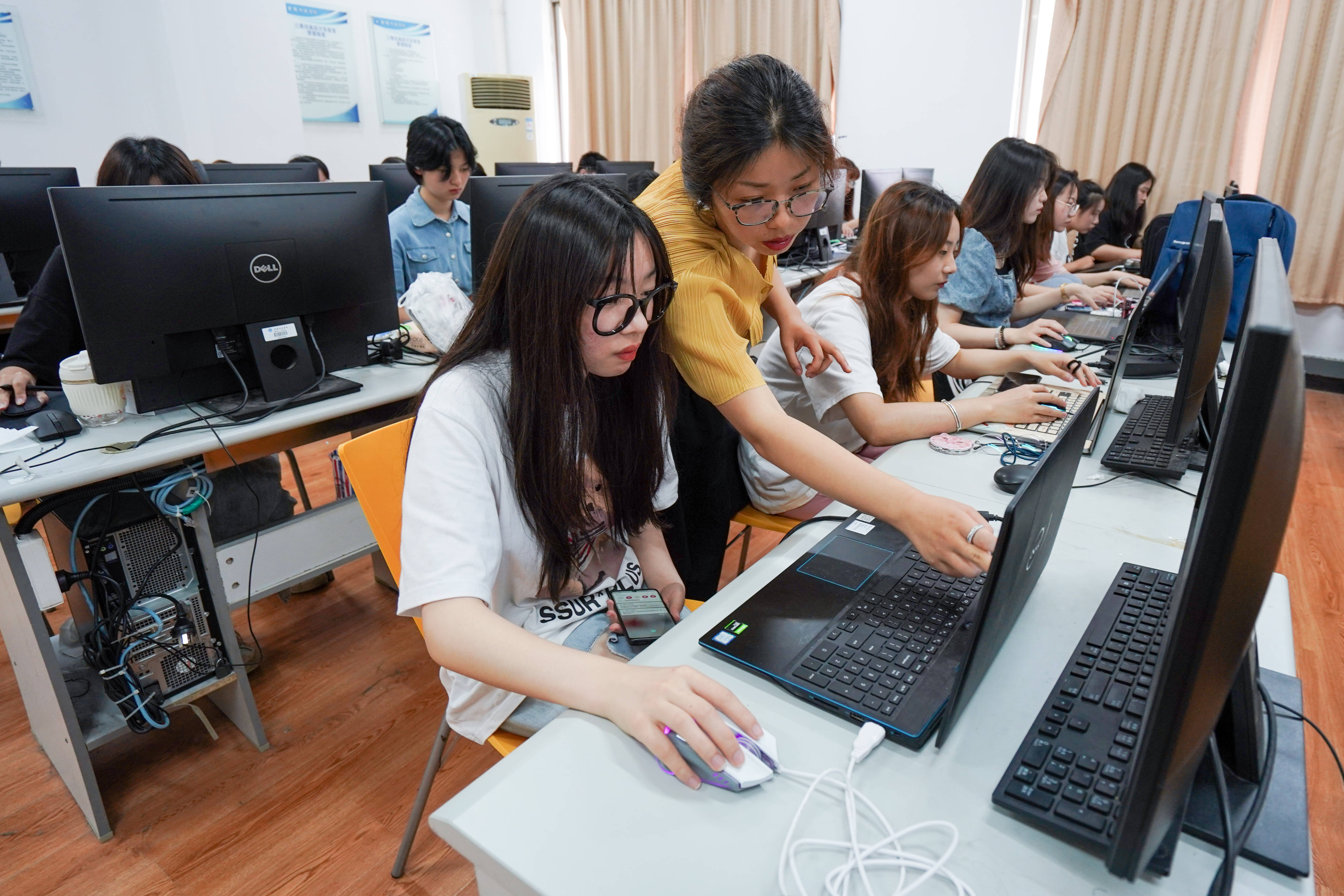 在金陵科技学院动漫学院,教师丁玲(前排左二)在指导学生学习原画设计