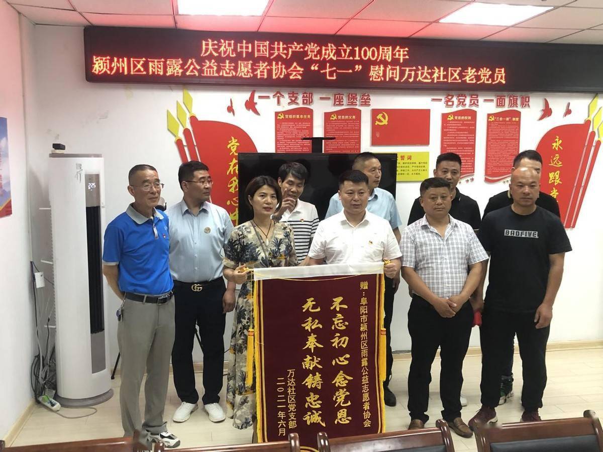 雨露公益志愿者协会送上印着"不忘初心念党恩,无私奉献铸忠诚"的锦旗