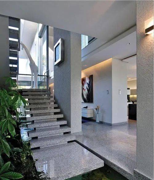 将天井鱼池与楼梯结构相结合,楼梯台阶顺势延伸出鱼池,视觉上具有一气