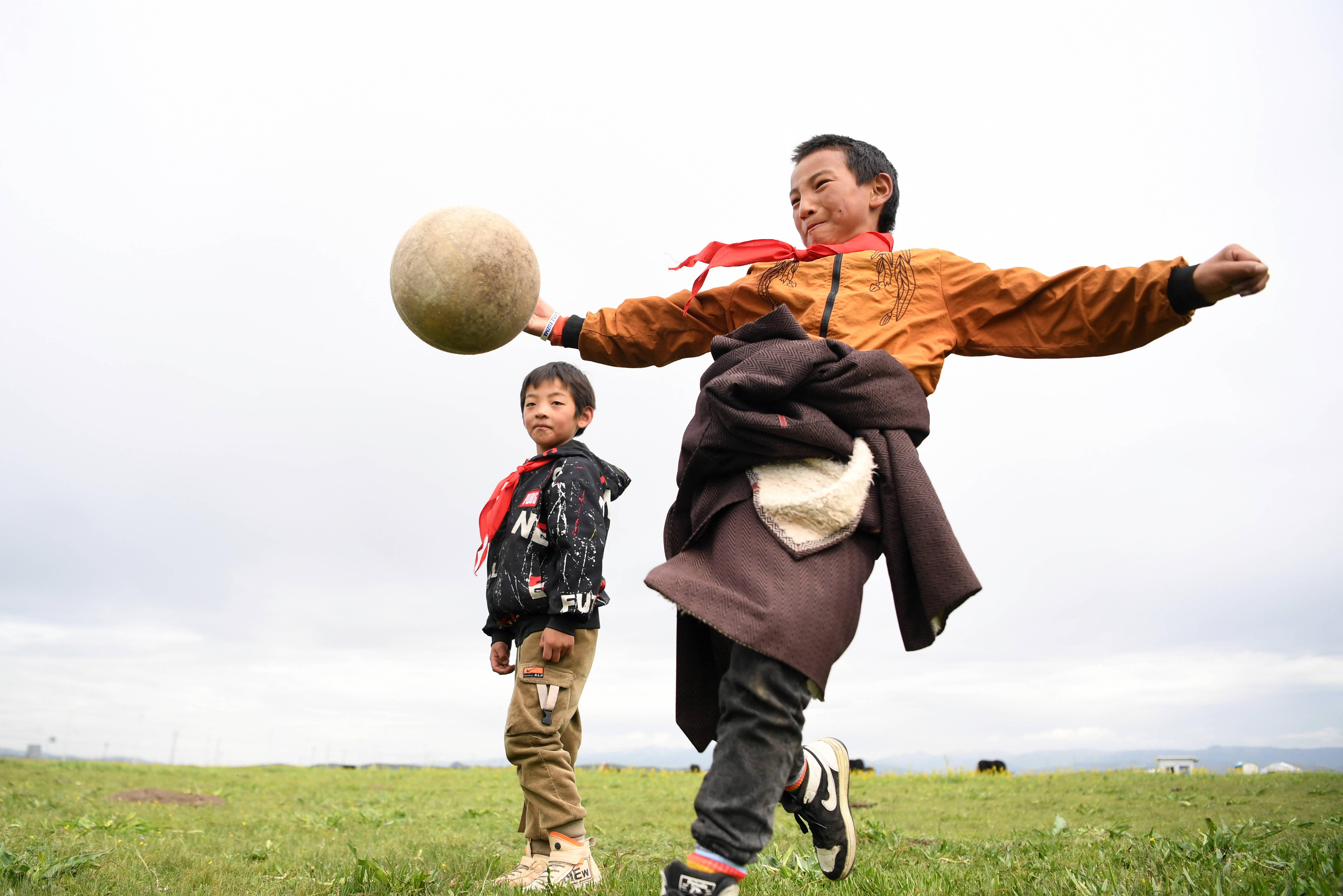 暑假7月14日,河曲马场小学学生参交罗布藏(右)和同伴在草原上踢足球