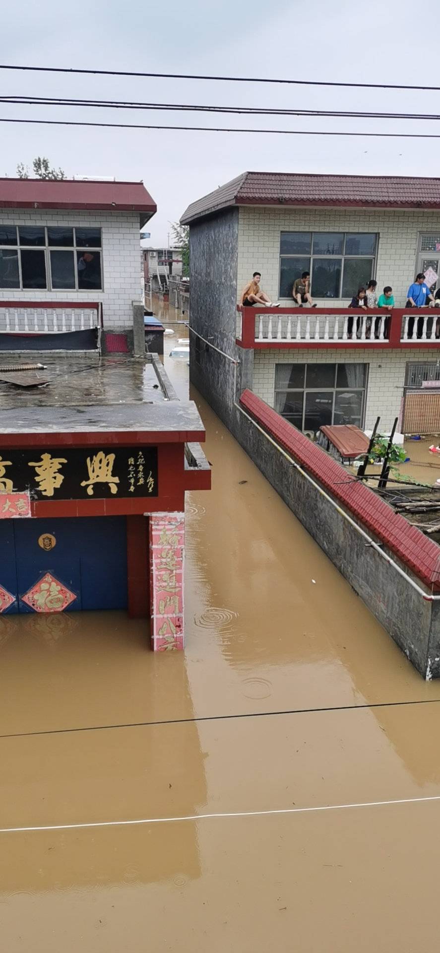 新乡暴雨被困者:涨水前村民们跑到二楼避险,目前还有老人和小孩被困
