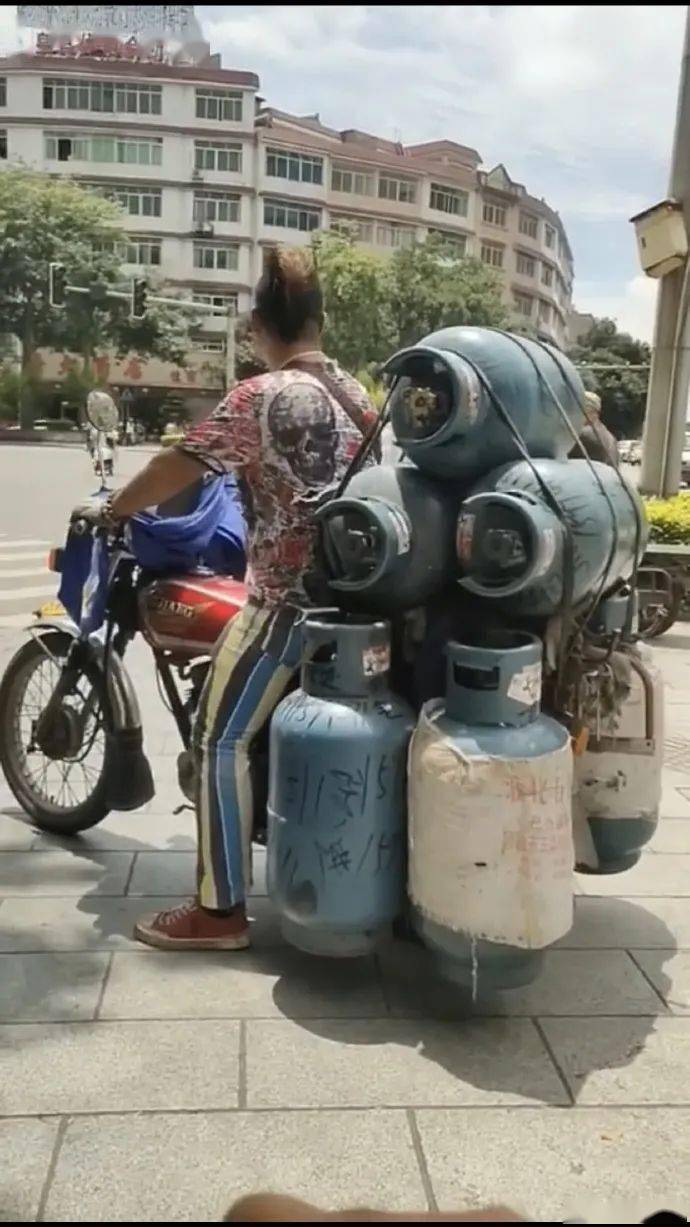 牙咽冇!一男子骑摩托车载7个煤气罐还不带帽
