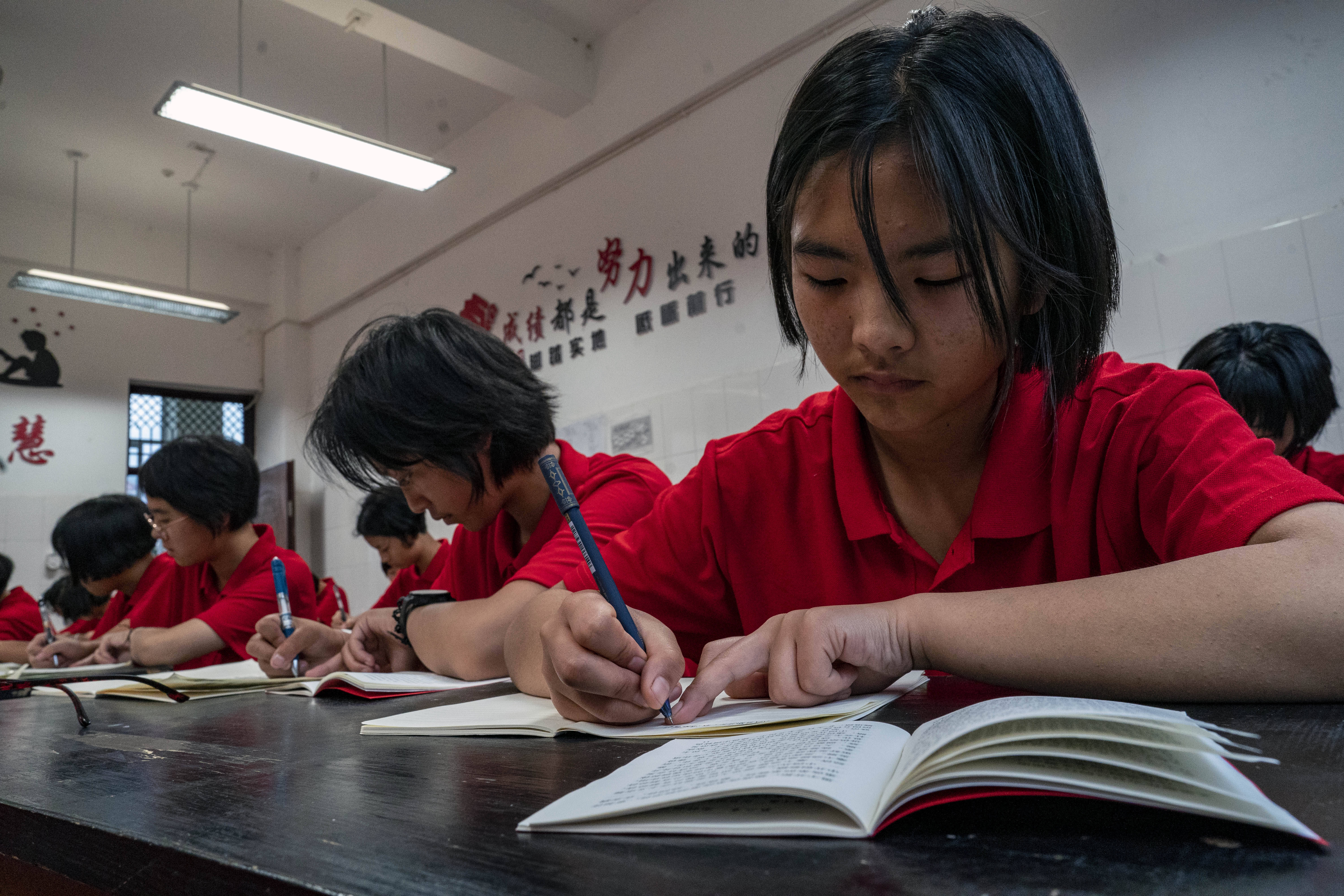 8月24日,杨丽梅与同学们一起在教室学习.