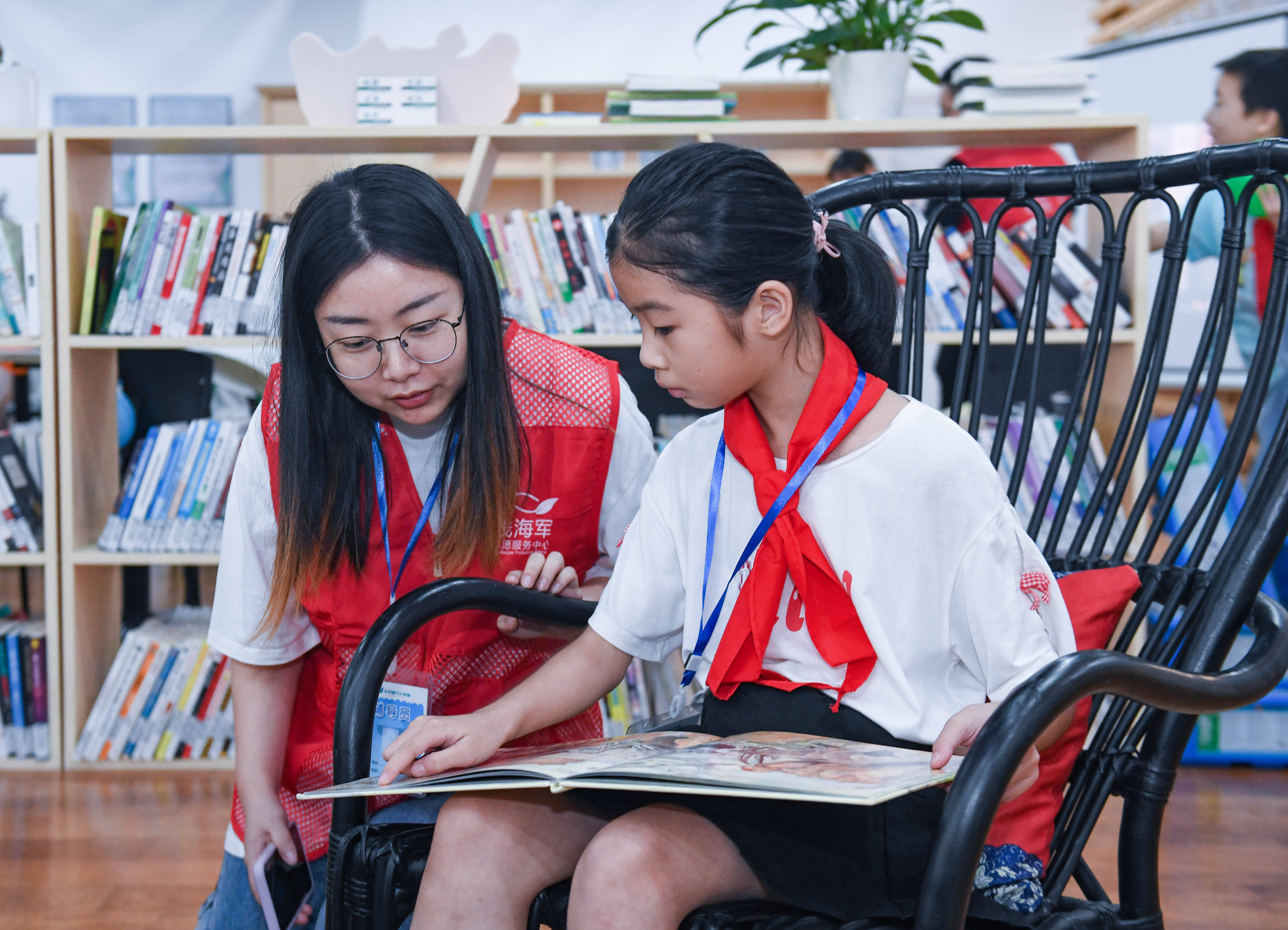 9月4日,小学生们在志愿者的指导下阅读感兴趣的书籍