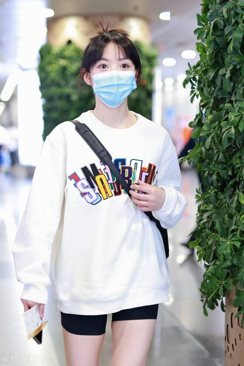 田曦薇头发盘起温婉不失可爱,身着白色卫衣,黑色短裤简约舒适