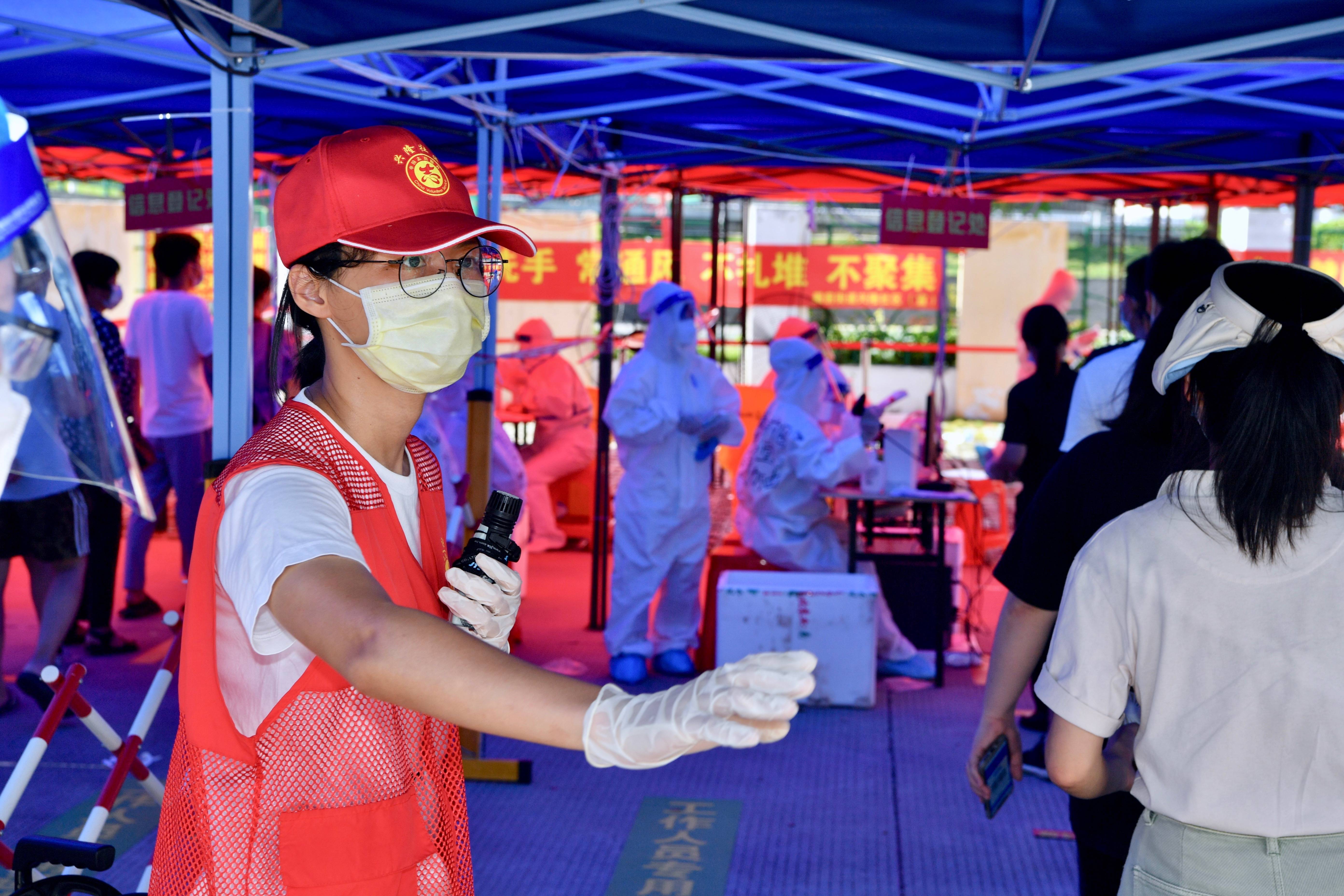 9月22日,在厦门思明区一核酸检测点,台胞志愿者张语真(左)在引导市民