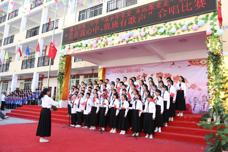 上午9时许,修文二中操场上,鲜红的地毯,透出节日的喜庆;彩旗,鲜花