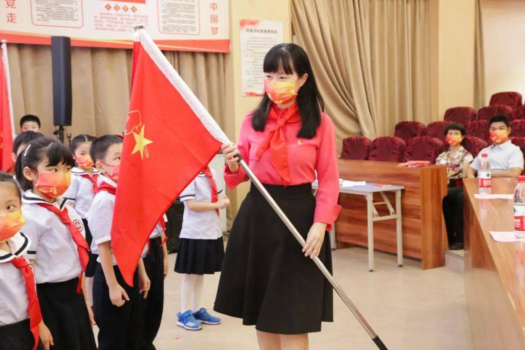 团市委副书记何艺晖为新队员代表授中队旗,并对新队员们给予殷切的