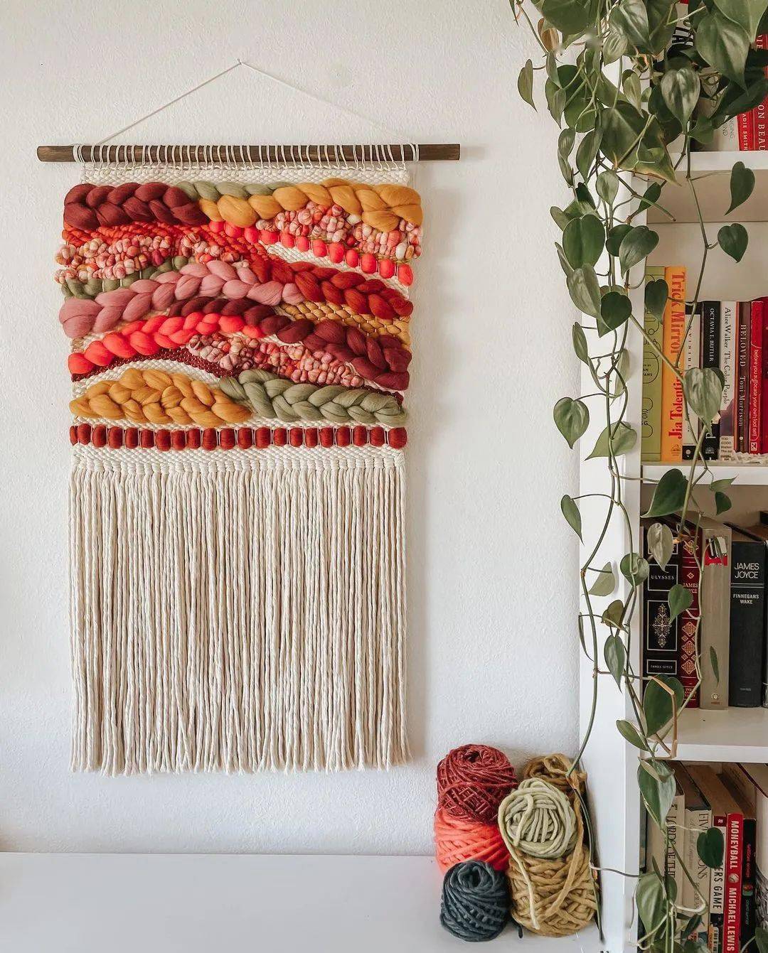 比起徒手编织的挂毯,这种毛线挂毯的工艺会更复杂,需要借助一个类似