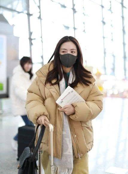 蔡文静身着卡其色西装现身机场.两条裤腿的搭配说明两条腿又细又直.