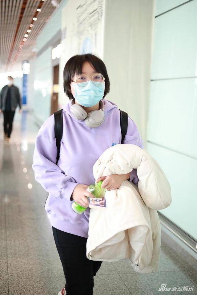 组图:李雪琴穿紫色卫衣现身机场 大口吃东西超接地气_北京_短发_造型