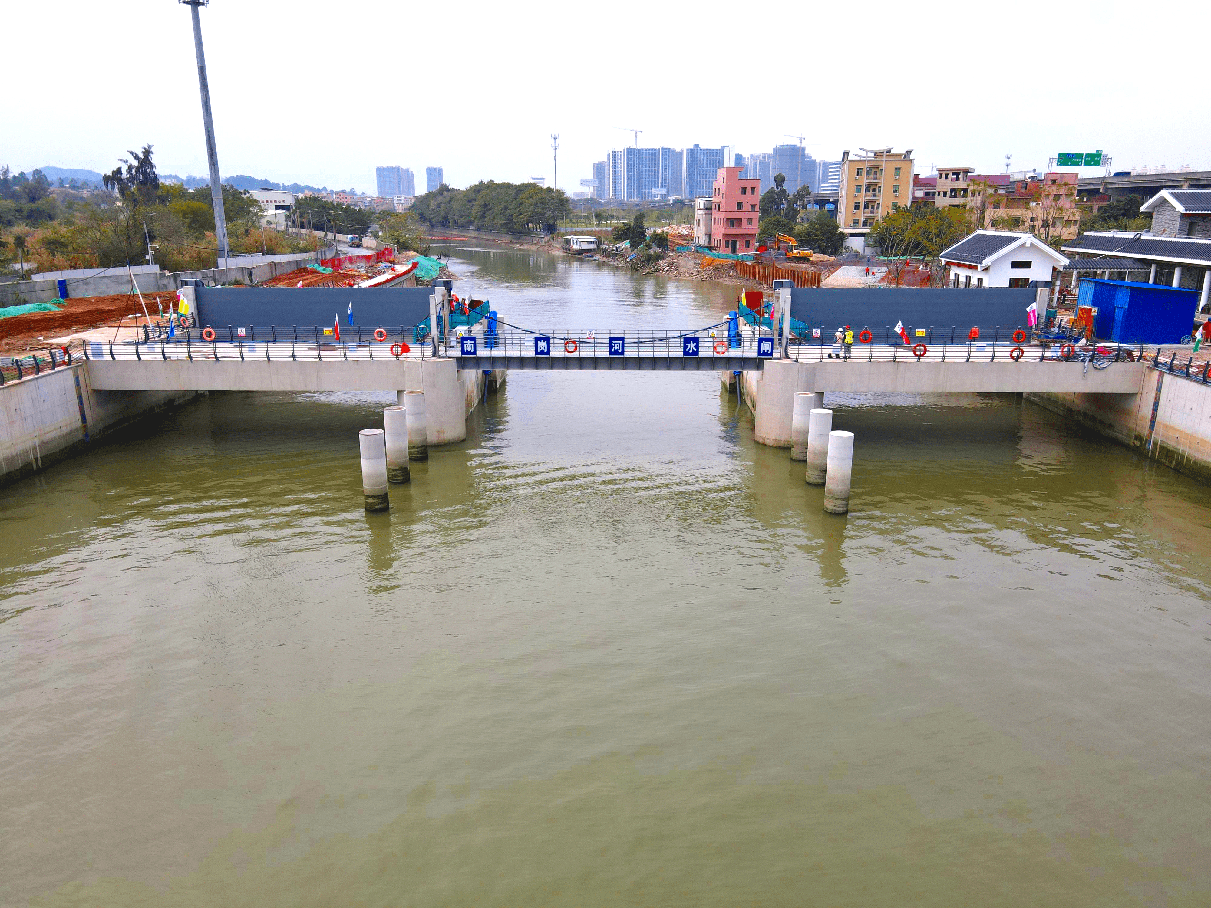 从空中俯视,南岗河,金紫涌两座水闸状如门栓,牢牢把住河水动向.