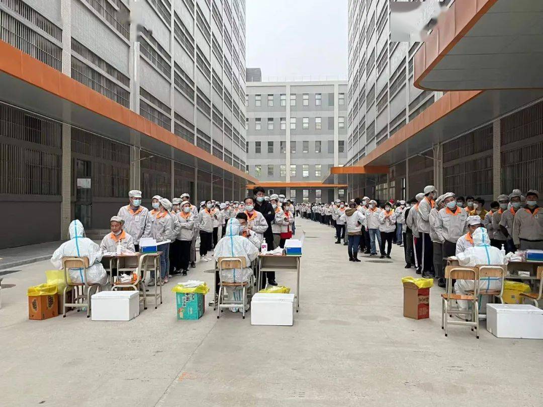在江海区德昌电机城核酸检测现场,员工正有序地进行核酸检测.