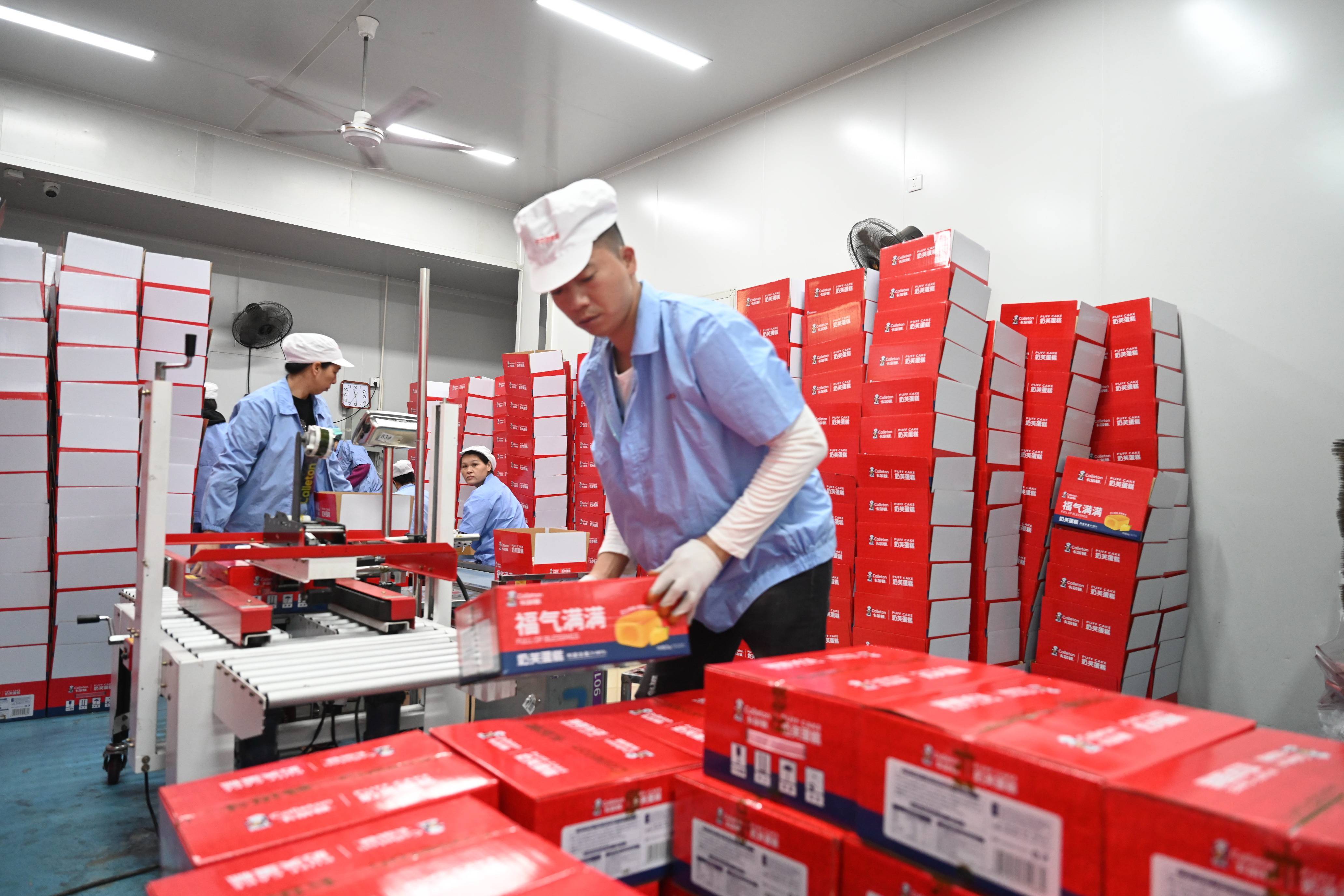 工人在位于福建漳州的紫山集团生产车间检查水产品罐头(2021年11月19