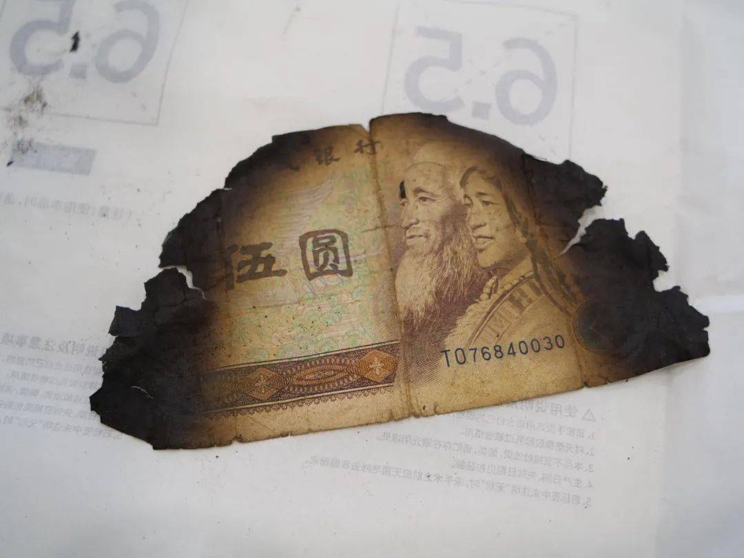工作人员正在认真核对纸币损坏面积原来,这些残币是高先生埋在地下