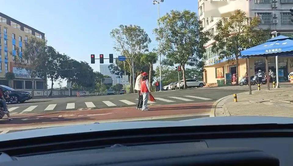 搀扶老人过马路小小举动暖人心文昌市志愿红成城市靓丽风景线