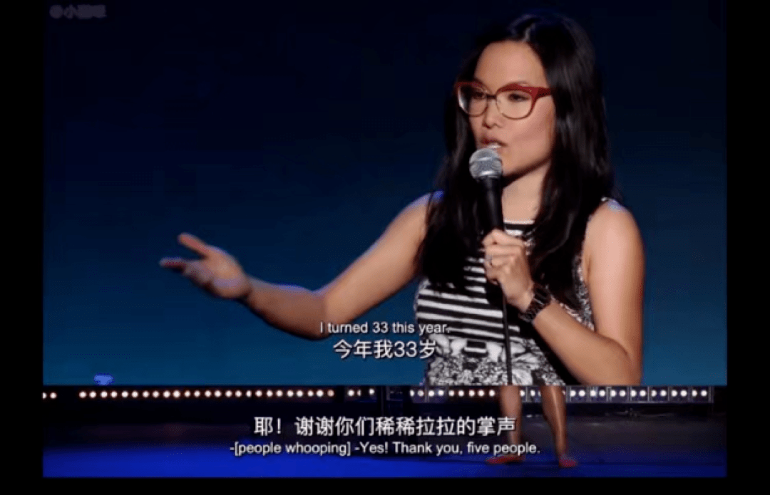 一个33岁的女人挺着孕肚,穿着一条蛇纹短裙,带着一副红框眼镜,在舞台