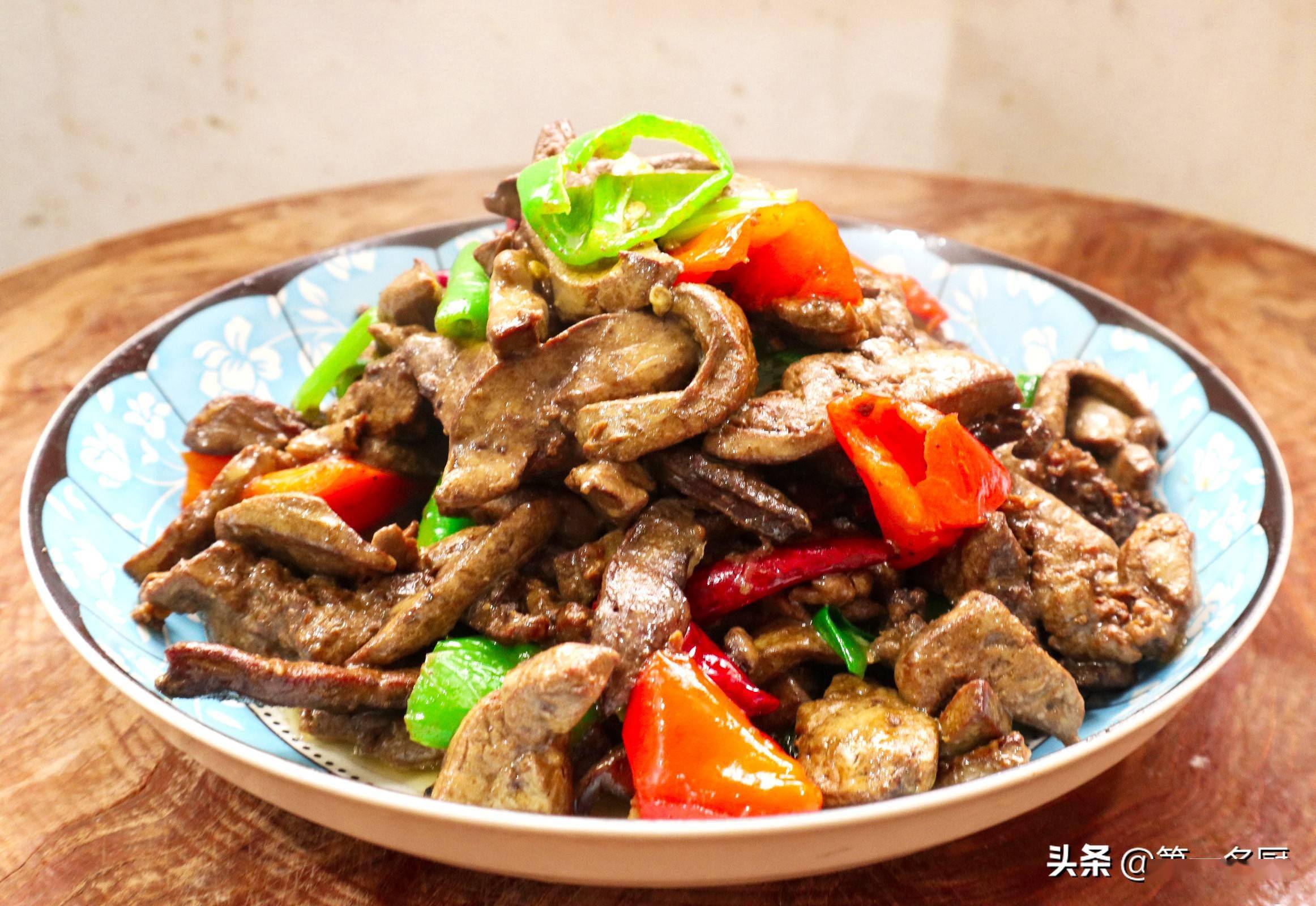 准备鸡肝一斤左右,切成薄片,放入盘中,红椒半个切成滚刀块,青椒一个