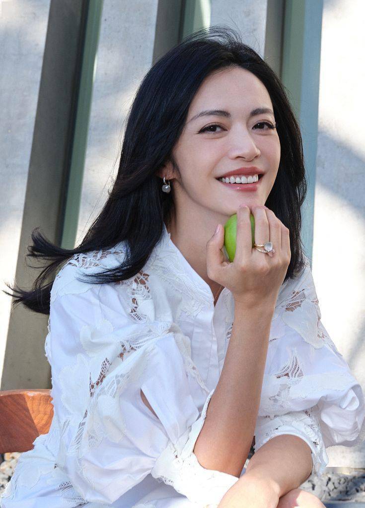 姚晨发丝飘逸.姚晨身穿白色镂空衬衫裙文艺十足.姚晨笑容迷人.