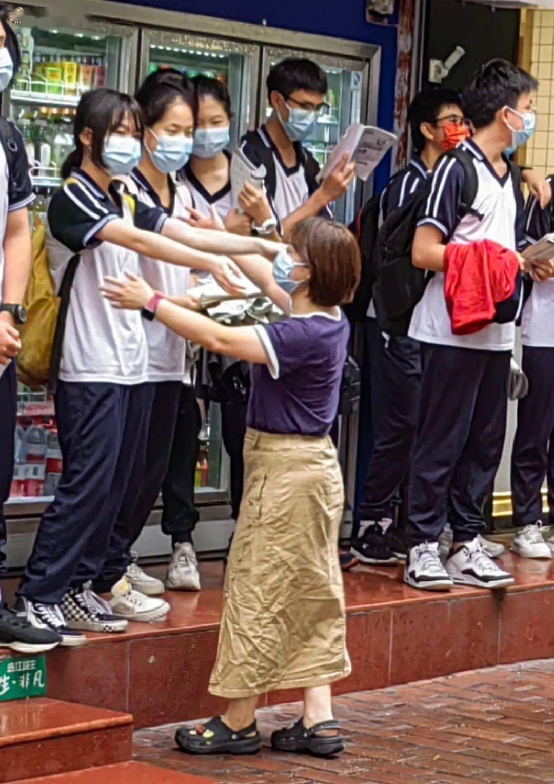 美华中学考点外,考生手拿学习资料,抓紧时间复习