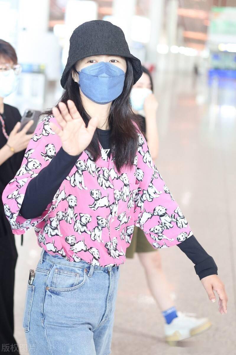 谭维维粉色小狗短袖搭牛仔裤现身机场捧鲜花人气旺