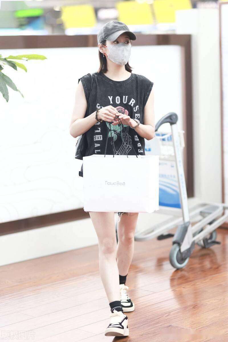 李纯新电影杀青现身机场嘻哈背心搭短裤身材纤瘦