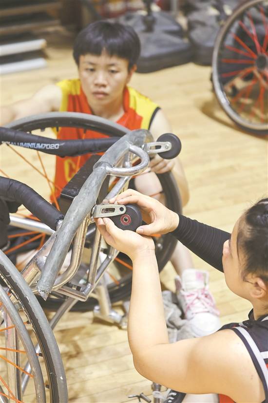 广东省女子轮椅篮球队助理教练兼队长林穗玲(中)带球进攻左佩烯独自