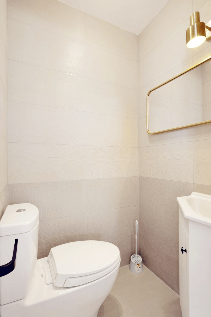 客卫简单的布局,马桶,洗手盆和挂毛巾架,墙面分色的瓷砖增加空间层次