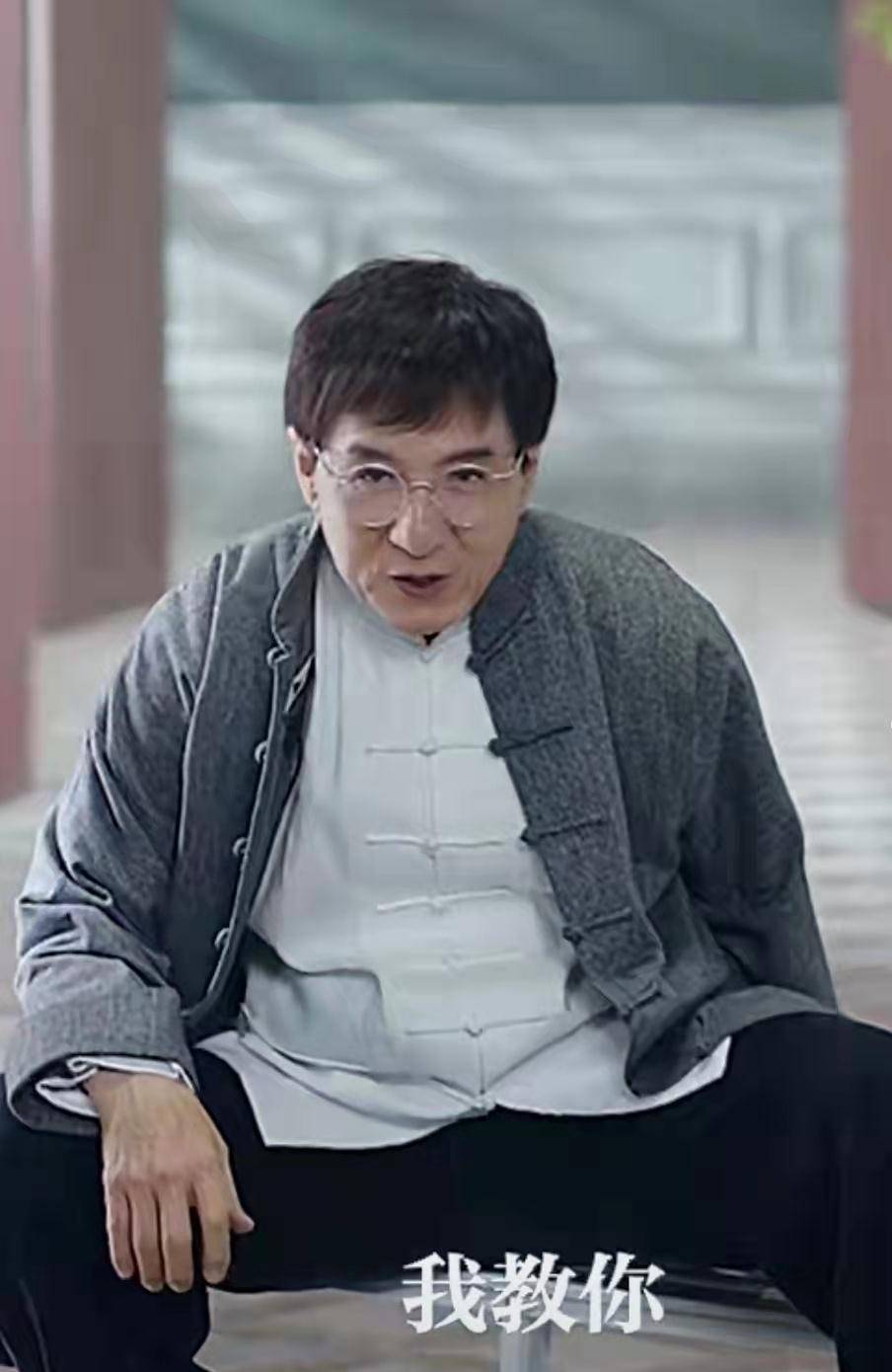 照片中,成龙的穿着标志性的中山装,黑白灰的基础配色很是朴素,让不少